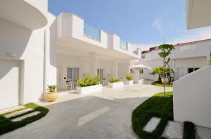 a white house with a courtyard with plants at Lefko Suites in Hanioti