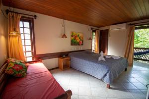 een slaapkamer met een bed met een knuffeldier erop bij Hotel Pousada Imbassai in Imbassai