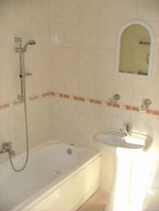 een badkamer met een bad, een wastafel en een douche bij Daugavkrasti Hotel in Jēkabpils