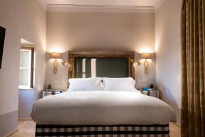 a bedroom with a large white bed with two pillows at The Xara Palace Relais & Chateaux in Mdina