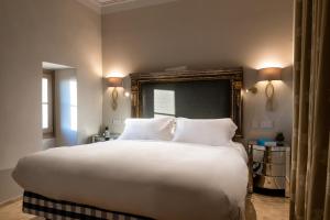 a bedroom with a large bed with white sheets and pillows at The Xara Palace Relais & Chateaux in Mdina