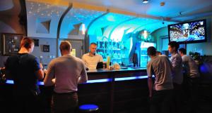 a group of people standing around a bar with a man at Hotel Partner in Mińsk Mazowiecki