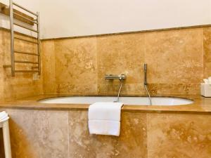 a bathroom with a bath tub with a towel at The Xara Palace Relais & Chateaux in Mdina