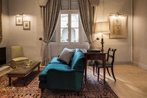 a living room with a blue couch and a table at The Xara Palace Relais & Chateaux in Mdina