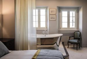 a bathroom with a tub and a sink and a bed at The Xara Palace Relais & Chateaux in Mdina