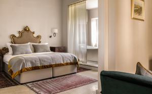 a bedroom with a bed and a window and a couch at The Xara Palace Relais & Chateaux in Mdina