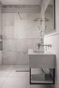 a white bathroom with a sink and a shower at The Xara Palace Relais & Chateaux in Mdina