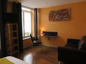 シャルルヴィル・メジエールにあるChambres du Petit Boisのソファ、椅子、窓が備わる客室です。