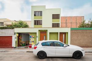 a white car parked in front of a building at Ayenda Casa Aika in Lima