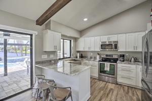a kitchen with white cabinets and appliances and a patio at Canal-Front Cape Coral Home: Pool & Patio in Cape Coral