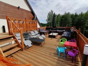 a large wooden deck with chairs and tables on it at Agroturystyka Blicharzówka Noclegi in Bukówka