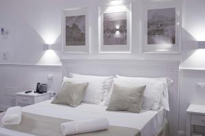 a white bedroom with a bed with white pillows at Palazzo Sant'Elena in Foggia