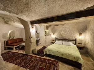 een slaapkamer met een bed en een bank in een kamer bij Takunya Cave Hotel in Nevsehir