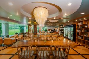 a large library with a large wooden table and chairs at Naithonburi Beach Resort in Nai Thon Beach