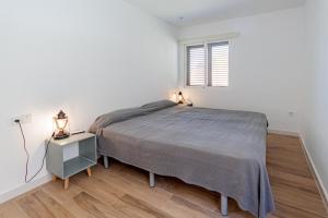 a white bedroom with a bed and a window at Optimist 2 in La Manga del Mar Menor