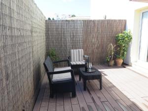 a patio with two chairs and a table and a fence at La Luna Blanca in Torremolinos