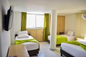 a hotel room with two beds and a window at Hotel Isla Capri in Cartagena de Indias