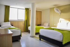 カルタヘナ・デ・インディアスにあるHotel Isla Capriのベッド2台と柱が備わるホテルルームです。