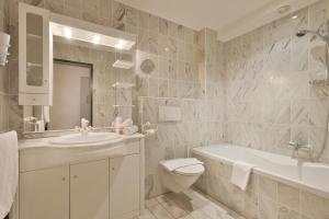 a white bathroom with a sink and a toilet and a tub at Apparthotel Tom Sojer in Ellmau +31 photos