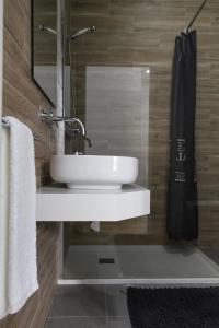 La salle de bains est pourvue d'un lavabo blanc et d'un miroir. dans l'établissement Varandas do Nabão, à Tomar