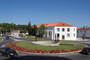 uma rotunda no meio de uma estrada com um edifício branco em Varandas do Nabão em Tomar