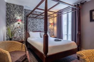 a bedroom with a large bed and a large window at Hotel London in Paris