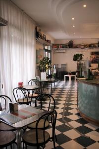 un restaurante con mesas y sillas en un suelo a cuadros en Albergo Moderno, en Módena
