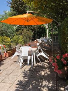 a table and chairs under an orange umbrella at Albergo Moderno in Modena