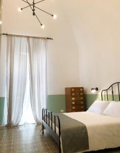 a bedroom with a bed and a large window at Caves Apartment in Bari