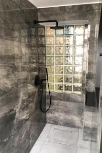 a shower with a glass door with a window at Caves Apartment in Bari