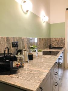 a kitchen with green walls and a counter top at Caves Apartment in Bari