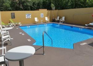una grande piscina con sedie e tavolo di Comfort Inn Blythewood - North Columbia a Blythewood