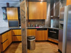 a kitchen with wooden cabinets and a stainless steel refrigerator at Apartment in the heart of Crans Montana in Crans-Montana