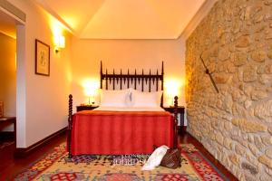 a bedroom with a bed and a stone wall at Casa Melo Alvim - by Unlock Hotels in Viana do Castelo