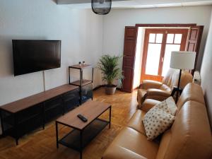 a living room with a couch and a flat screen tv at Casa del Beso II in Luarca