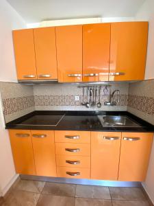 kuchnia z pomarańczowymi szafkami i zlewem w obiekcie Yumbo house w mieście Maspalomas +3 zdjęcia