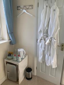 a bathroom with white towels hanging on a door at Willow Farm Way in Herne Bay