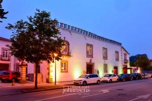 a white building with cars parked on the side of a street at Casa Melo Alvim - by Unlock Hotels in Viana do Castelo