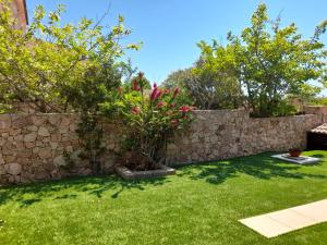 プーラにあるVilla Sa Murta Biancaの石造りの壁と緑の庭がある庭園