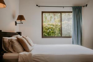 um quarto com uma cama e uma janela em The Golden Frog Inn em El Valle de Antón