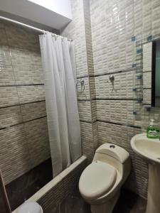 a bathroom with a toilet and a sink at Apartamento Hogareño con 3 dormitorios in Huancayo