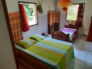 una camera da letto con due letti e due finestre di Peaceful House a Vieux-Habitants