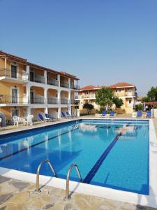 une grande piscine en face d'un hôtel dans l'établissement Village Inn Studios & Family Apartments, à Laganas