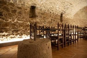 a room with a table and chairs in a stone wall at Casa Rural Zacarías in Sardón de Duero