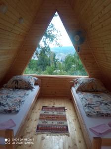 two beds in a room with a large window at Bungalovi Lana in Sarajevo