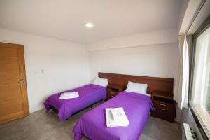 two beds in a room with purple blankets at Edificio Pampa II in Añelo