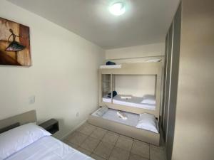 ジョインヴィレにあるAp aconchegante no centro de Joinville com vagaの小さなベッドルーム(ベッド2台、鏡付)