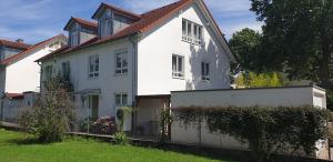ein weißes Haus mit einem Zaun im Hof in der Unterkunft Ferienhaus Marina in Weil am Rhein