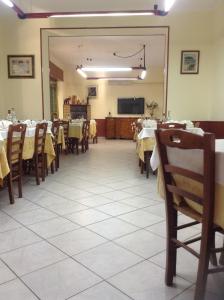 ein Esszimmer mit Tischen, Stühlen und einem Spiegel in der Unterkunft Hotel 4 Lampioni in Cropani