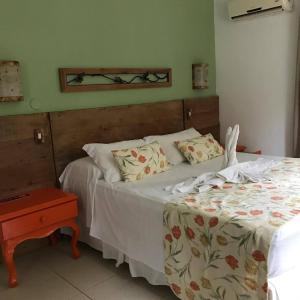 um quarto com uma cama e uma mesa de cabeceira ao lado em Pousada Tatuapara na Praia do Forte